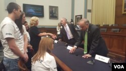 听证后,国会众议院移民与边境安全小组委员会主席、共和党议员高迪(Rep. Trey Gowdy)与非法移民犯罪的受害者家属罗拉 威尔克森握手,共和党议员史蒂芬.金(Rep. Steve King)与另一位家属米歇尔 如特交谈。(美国之音魏之拍摄)