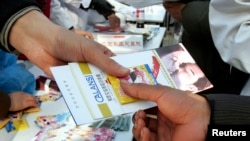 一名中国志愿者在一次宣传活动中散发免费避孕套和有关艾滋病/HIV知识的小册子。(资料照)