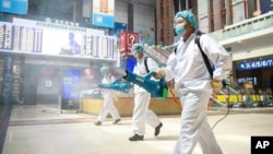 工作人员在北京火车站喷洒消毒剂。（2020年6月18日）