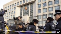 2010年2月11日中国警察监视正在等候北京最高法院前的记者们,他们报导刘晓波被控以“煽动颠覆国家政权罪”被判刑11年的上诉案审理情况。