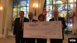 台湾捐赠美国红十字会的50万美元支票,左起为美国国务院台湾协调处处长何乐进、台湾驻美代表高硕泰、美国红十字会会长麦戈文女士、美国在台协会执行理事罗瑞智(2017年9月12日,美国之音钟辰芳拍摄)