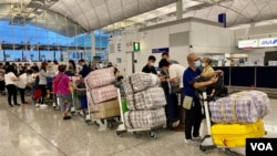 英国LOTR安排届满前夕,7月18日晚香港国际机场出现移居英国的人潮,他们推着堆积如山的行李,港人惯用的大型”红白蓝袋”成为机场特别的风景。(美国之音汤惠芸)