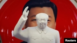 北京天安门附近一个纪念品商店里毛泽东的塑像摆在习近平纪念画盘的前面。(2018年3月1日)