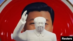 北京天安门附近一个纪念品商店里毛泽东的塑像摆在习近平纪念画盘的前面。(2018年3月1日)