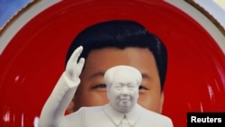 北京天安门附近一个纪念品商店里毛泽东的塑像摆在习近平纪念画盘的前面。(2018年3月1日)