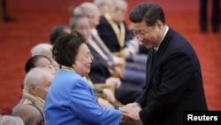 中国国家主席习近平在纪念中国抗日战争胜利60周年的一次颁奖仪式上与飞虎队将军陈纳德的遗孀陈香梅握手。(2015年9月2日)