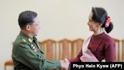 2015年,昂山素季(右)与缅甸军方领导人敏昂莱(左)握手。