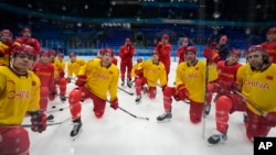 参加北京冬奥会的中国冰球队运动员在赛前练习时倾听教练讲话。(2022年1月30日)