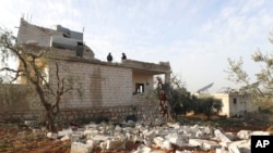 在叙利亚伊德利卜省的阿特梅赫镇,在美军展开一次突击行动后,人们查看被毁坏的一座房屋。(2022年2月3日)