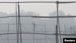 一名劳工在雾霾中的新德里拆除脚手架。(资料照)