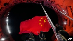 资料照:中国军人在冬运会开幕式上升起中国国旗。(2022年2月4日)