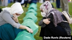 在波斯尼亚和黑塞哥维那斯雷布雷尼察附近的波托卡里,妇女们在家人的棺材旁哭泣。波斯尼亚纪念屠杀8000多名波斯尼亚穆斯林男子和男孩25周年。(2020年7月11日)