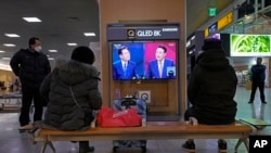 韩国民众在首尔火车站观看两位总统候选人的电视辩论直播。(2022年2月3日)