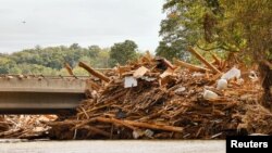 2024年10 月1日,在北卡罗来纳州的烟囱岩,热带风暴海伦过境期间,一场猛烈的洪流席卷了布罗德河,大量残骸滞留在通往城镇的桥梁上。