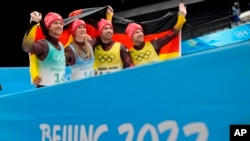 德国雪橇滑手娜塔莉·盖森伯格 (Natalie Geisenberger,左二) 与队友夺得北京冬奥会雪橇接力赛冠军(美联社2022年2月10日)