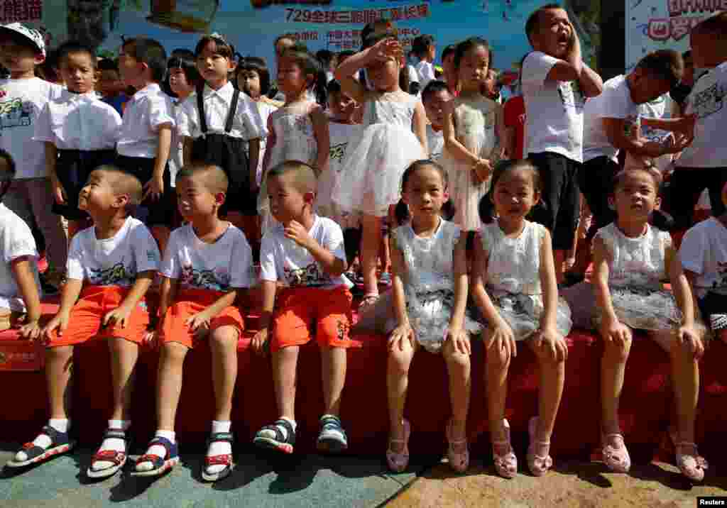 在中国广州长隆野生动物园,三胞胎儿童庆祝世界上唯一的大熊猫三胞胎萌萌、帅帅和酷酷的4岁生日(2018年7月29日)。