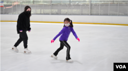 母亲是华裔的贝萨妮·布朗跟教练阿德里安娜·德桑克蒂斯学习新动作编排(VOA视频截图)