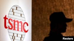 资料照：在台北的一次投资会议期间一名保安站在台积电标识旁。（2014年7月16日）