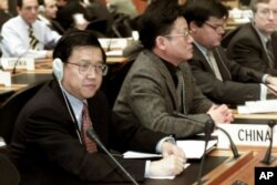 资料照:2001年12月19日星期三,中国首席贸易谈判代表龙永图(最左边)出席在瑞士日内瓦举行的世界贸易组织总理事会会议。中国作为世界贸易组织的新成员首次参加了这次会议。