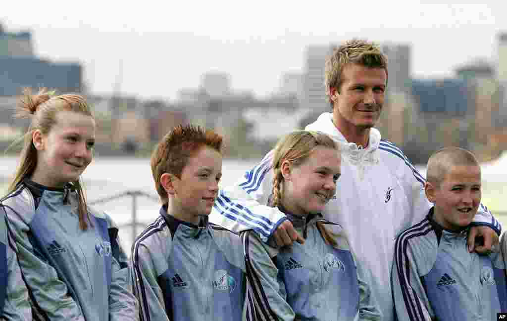 Beckham chụp chung với các học sinh tại ngôi trường cũ của mình nhân dịp khánh thành Học viện David Beckham ở London, 14 tháng 3, 2005.
