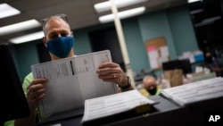 威斯康星州的选举工作人员在选举日整理提前投票和邮寄选票 (美联社 2020年11月3日)