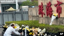 人们在珠海体育中心外摆放花束悼念遭恶意开车冲撞的受害者,但外媒目击悼念物品随后被官方人员移除。(美联社:2024年11月13日)