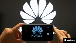 资料照:一支手机屏幕上显示的华为标识。