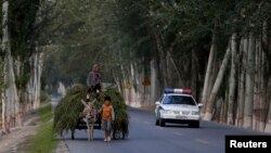 Xe cảnh sát Trung Quốc tuần tra ở thị trấn Aksu trong khu vực Tân Cương.