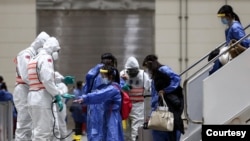 台湾防化兵在对从武汉飞抵桃园机场包机的台湾人进行防疫消毒作业。(台湾国防部军闻社提供)