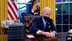 资料照片:拜登总统在白宫签署他就任后的第一个行政命令。(2021年1月20日)