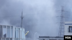 天津爆炸事故现场,核心爆炸区周围多座居民楼窗户被震碎,高速公路桥梁受损,多辆大货车被炸翻,小汽车起火或被砸,多名当地居民仍逗留在事故现场。(美国之音记者东方拍摄)