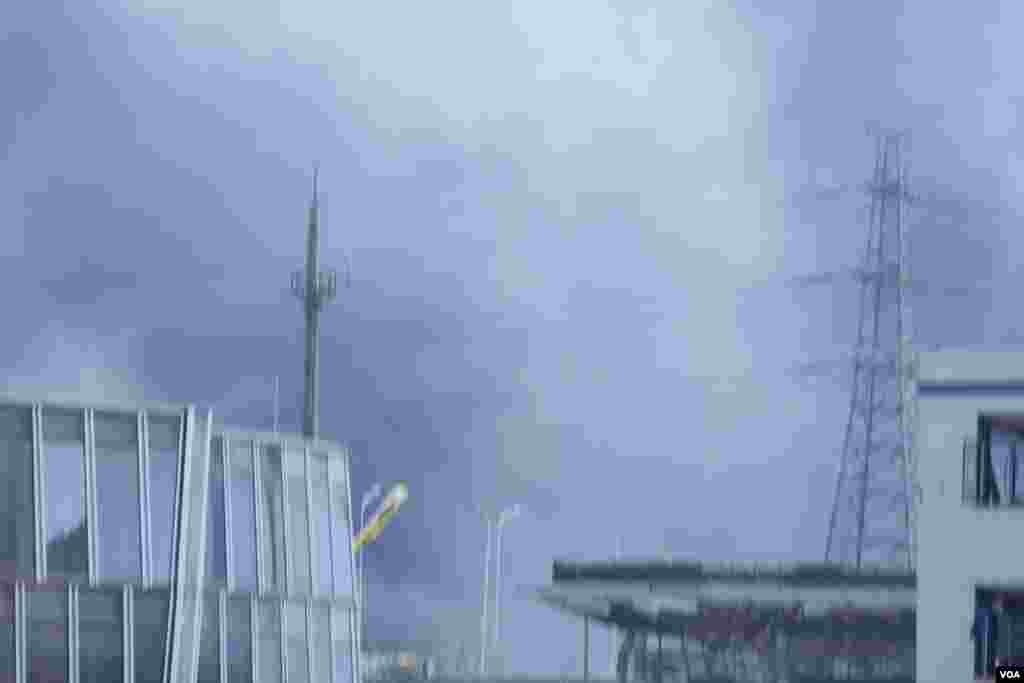 天津爆炸事故现场,核心爆炸区周围多座居民楼窗户被震碎,高速公路桥梁受损,多辆大货车被炸翻,小汽车起火或被砸,多名当地居民仍逗留在事故现场。(美国之音记者东方拍摄)