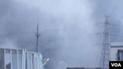 天津爆炸事故现场,核心爆炸区周围多座居民楼窗户被震碎,高速公路桥梁受损,多辆大货车被炸翻,小汽车起火或被砸,多名当地居民仍逗留在事故现场。(美国之音记者东方拍摄)