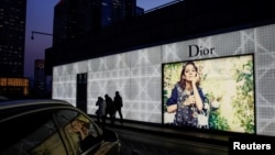 北京市民走过一家商场外的迪奥广告牌。(2016年11月30日)