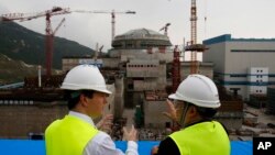 资料照:时任英国财相的奥斯本(左)参观中国建设中的广东台山核电站。(2013年10月17日)