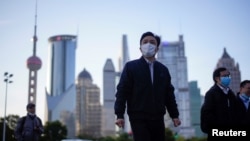 戴着口罩的行人行走在上海陆家嘴金融区的街道上。(2020年3月19日)