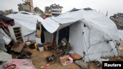 2025年2月6日,以色列和哈马斯之间的停火期间,一名巴勒斯坦男子在雨天坐在加沙的帐篷外。