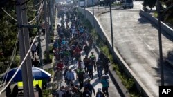 2018年11月9日,一群中美洲移民离开墨西哥城的耶稣马丁内斯体育场临时避难所后重新踏上了他们的旅程。