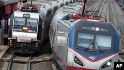 资料照片:一列美铁公司的火车沿着东北走廊铁路线行驶经过一列新泽西运输公司的火车。(2016年3月12日)