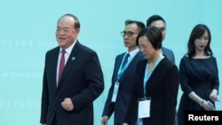 北京认可的澳门唯一的行政长官候选人贺一诚(左一)在澳门出席一个会议。