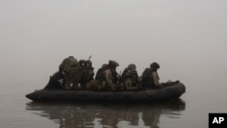 资料照片:2023年10月14日,乌克兰陆战队员在赫尔松附近前线渡过第聂伯河。(美联社照片)