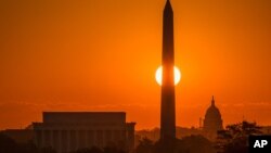 华盛顿旭日东升,离美国之音总部不远的国会大厦、华盛顿纪念碑和林肯纪念堂沐浴在金辉中