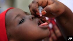 资料图片:尼日利亚卫生官员对儿童进行小儿麻痹症疫苗免疫工作