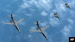 韩国空军战斗机(右三、右四)2017年6月20日伴飞美国的B-1B轰炸机(左一、左二)