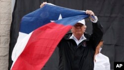 在德克萨斯州科珀斯克里斯蒂市,美国总统川普在发表讲话后挥舞着德克萨斯州的州旗(2017年8月29日)