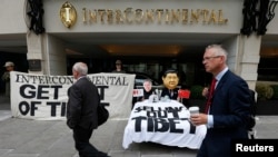 总部设在伦敦的支持藏人权利团体“自由西藏”在洲际酒店门前示威,有人戴着习近平和洲际酒店集团首席执行官的面具。(2013年8月5日)