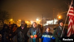 弗格森示威者在大陪审团裁定免予起诉密苏里州白人警察威尔逊后连续第三夜示威抗议,喊口号(2014年11月26日)