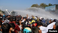 缅甸警察在首都内比都向示威民众射水驱散人群(路透社2021年2月9日)