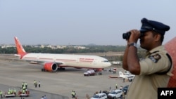 一名印度警察在海得巴拉的一个机场观察停机坪,一架印度航空公司的波音777客机停在那里。(资料照片)