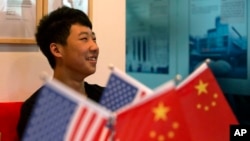 一位16岁的中国学生在北京一家教育机构里的美中两国国旗旁(2014年6月26日)
